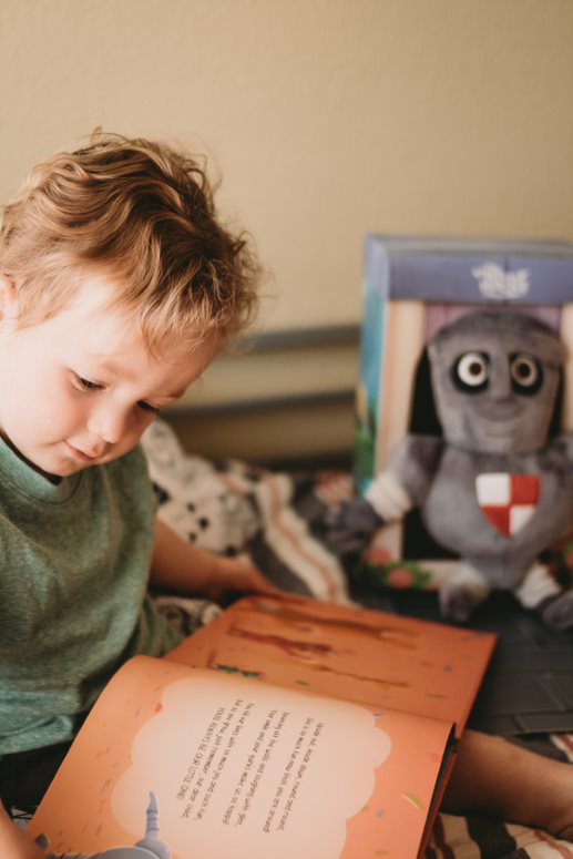 A child with a personalized milestone book from Hooray Heroes.