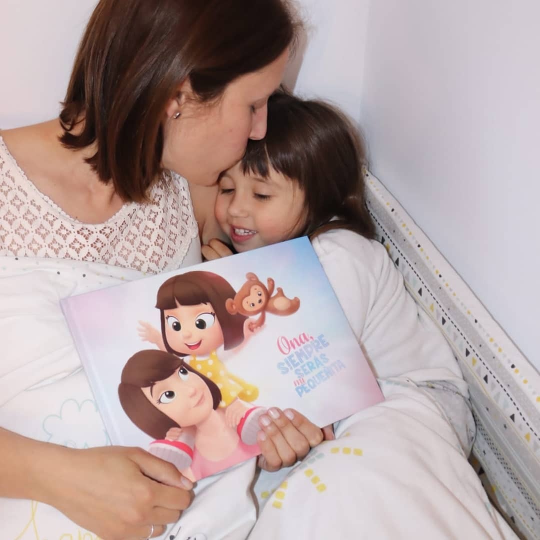 A mom and her daughter with a personalized book for the two of them.