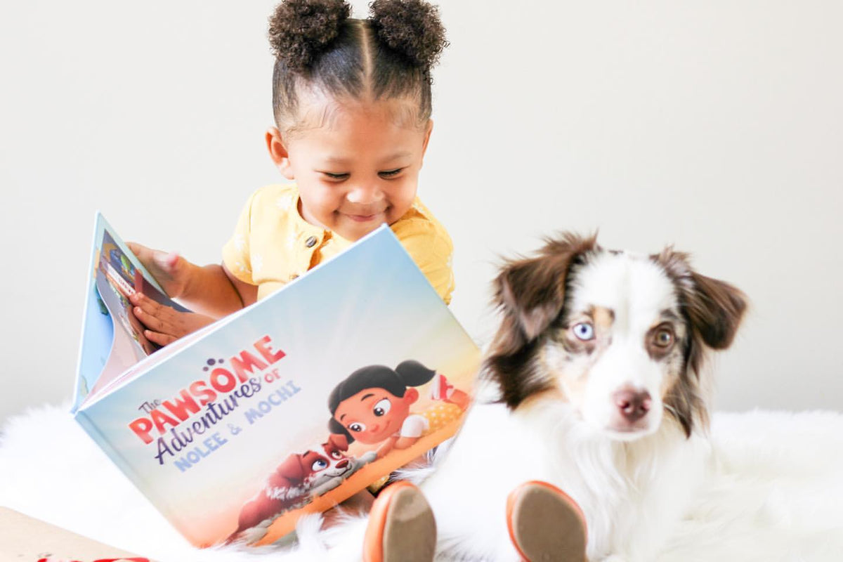 A little girl reads a personalized pets book to her dog.