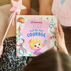 A girl is holding the new personalized book about a princess who found her courage.