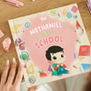 Personalized book about going back to school on the table with pens and paper. 