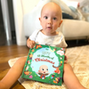 Little boy holding his new personalized book for Christmas with his character on the cover.