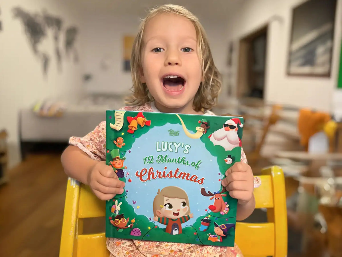 Little girl is holding her Christmas present - a festive personalized book.
