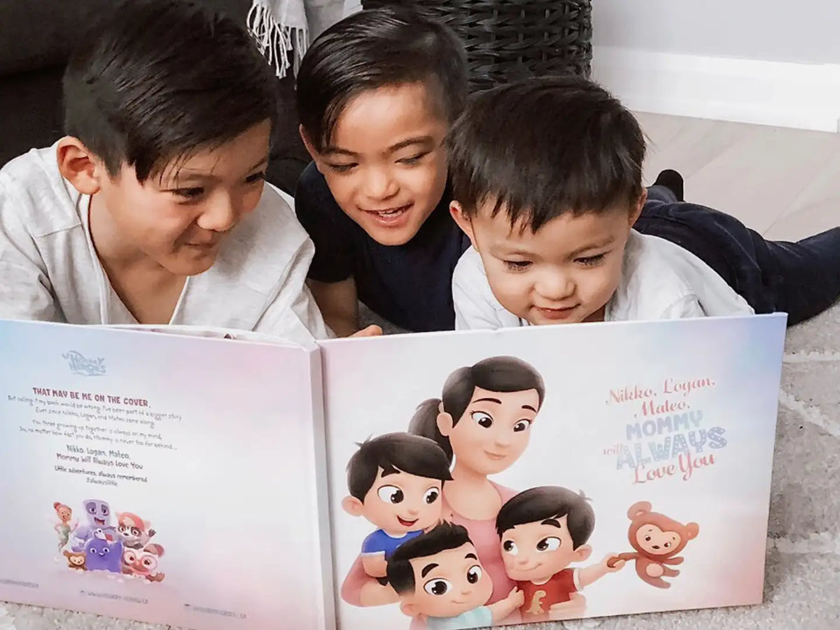 Three boys lying on the floor and reading their DIY book for them and mom they got as a birthday present.