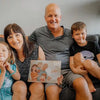 A family about to read a grandparents gift idea: a Hooray Heroes' personalized book for granny and grandpa with the kids.