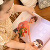 Girl looking at beautiful illustrations from her new personalized mom book.