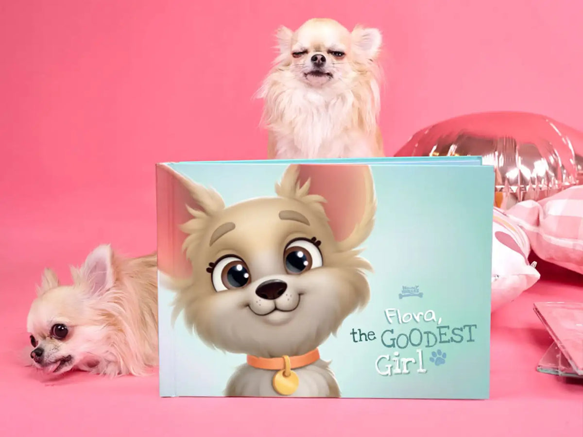 Person holding the dog book 'Flora the Goodest Girl' with a cute cartoon dog on the cover which is a great gift for dog owners.
