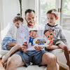 Dad reads his two children a custom book for friends, cousins, or siblings. 