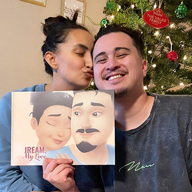 A wife kisses her husband who has received a highly customized love book for Christmas.