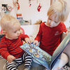 Children look at the pictures in their custom Xmas book for two kids. 