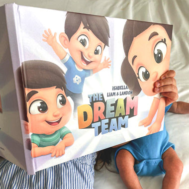 Children hold up the cover of their personalized siblings book that takes them all on a treasure hunt.