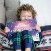 A child holds up their customized Christmas book from Hooray Heroes.