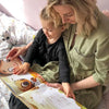 A mom and her four-year-old reading her personalized birthday book from Hooray Heroes.