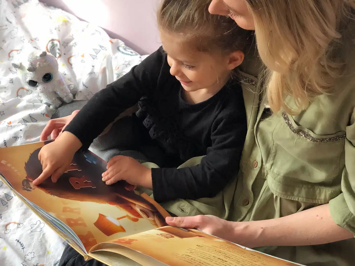 A mom and her five-year-old reading her personalized birthday book from Hooray Heroes.