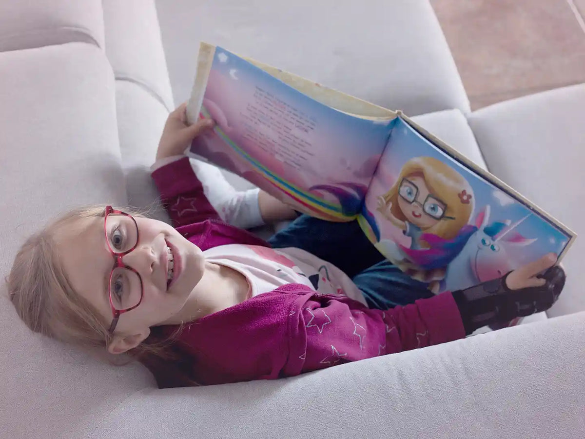 A six-year-old girl is reading her personalized birthday book.