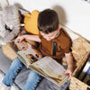 A seven-year-old boy is reading his personalized birthday book.