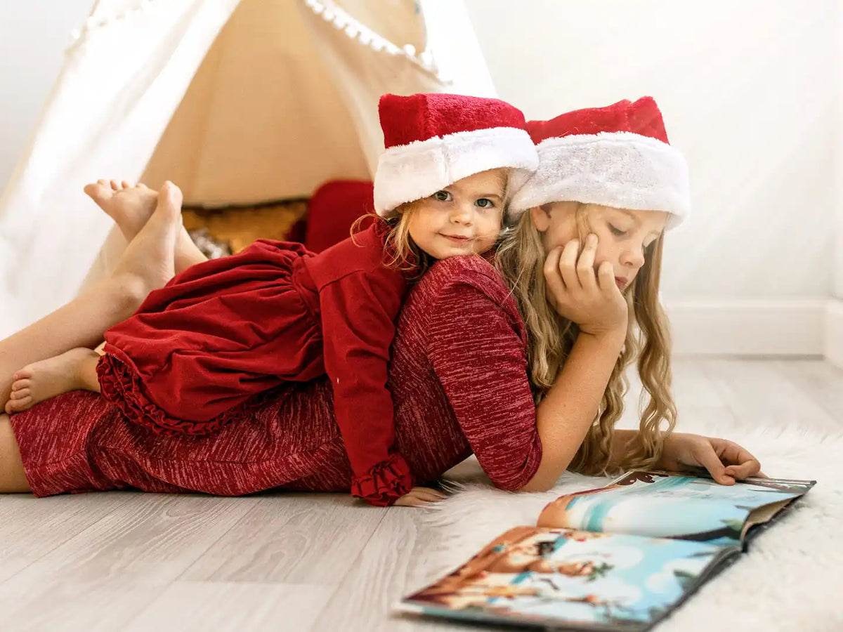 Two girls reading a personalized Christmas special book.