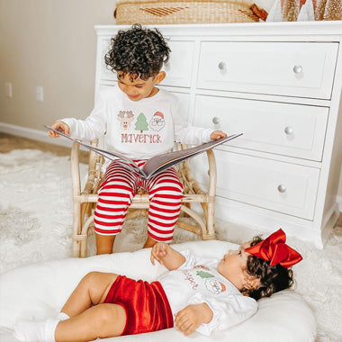 A boy reads his little sister a custom Xmas book just for the two of them, an amazing Christmas gift for siblings. 