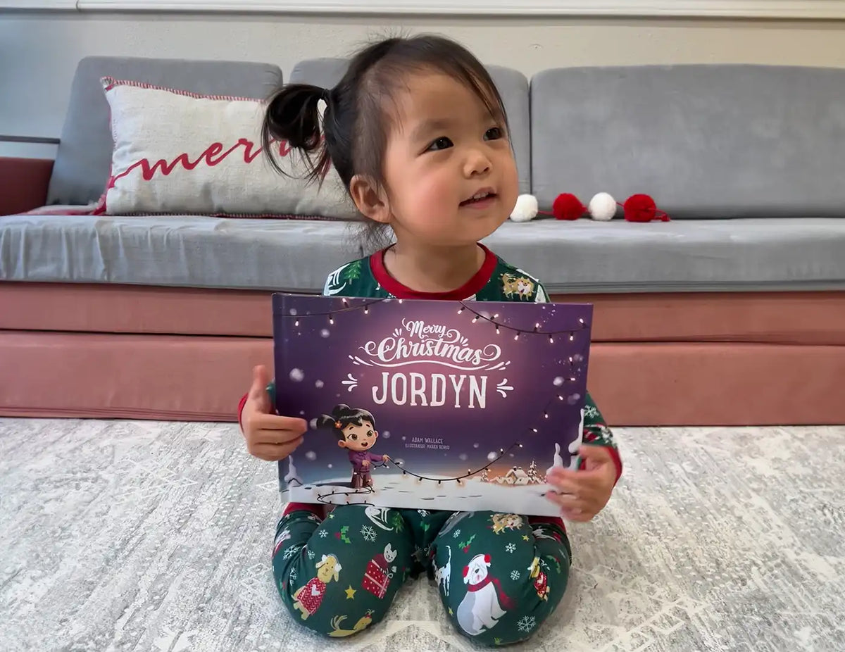 Girl is holding her custom storybook about Christmas which is the best gift under the Christmas tree.