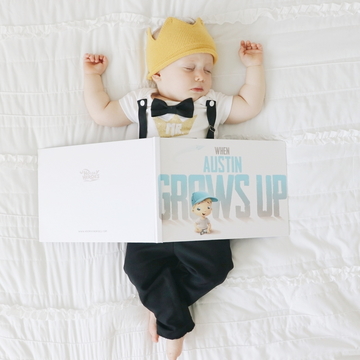 A baby sleeps with a personalized book about him growing up.