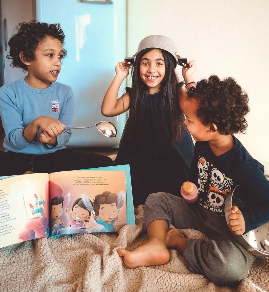 Three little siblings recreating one of the stories of our personalized book.
