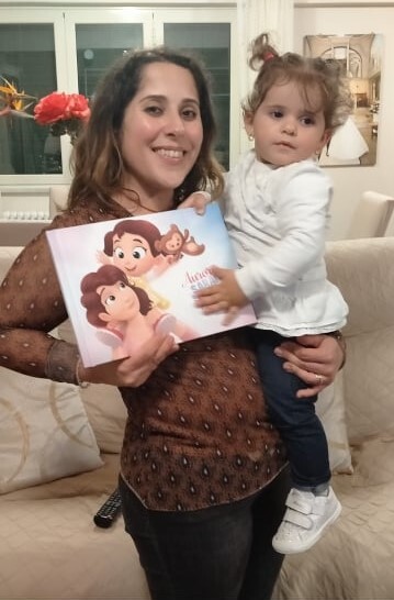 A mom and her daughter with a personalized book for the two of them.