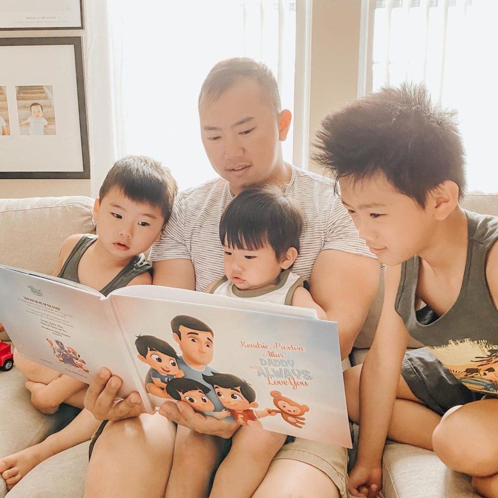 A family of four reading the personalized book by Hooray Heroes.
