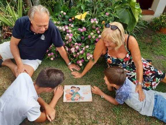 Grandparents reading a personalized book for grandparents to their two grandsons.