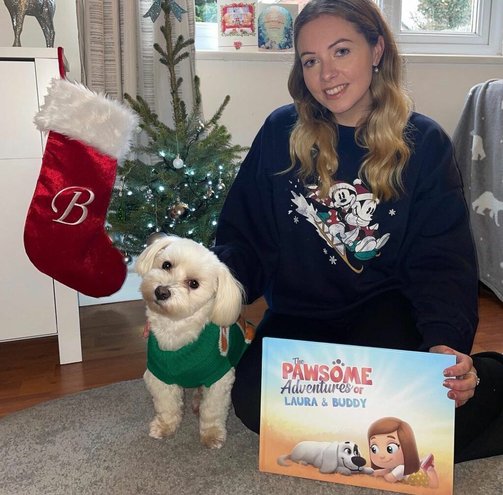 A woman and her dog at Christmas with a custom book just for the dog and human.