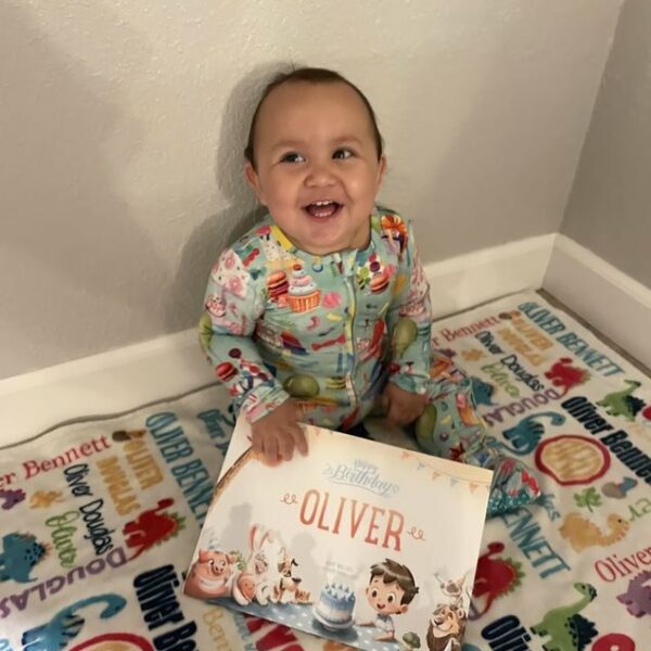A little boy called Oliver with a personalized Birthday Book by Hooray Heroes.
