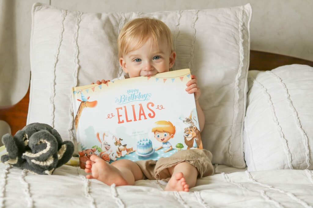 A little boy with the personalized birthday book by Hooray Heroes.