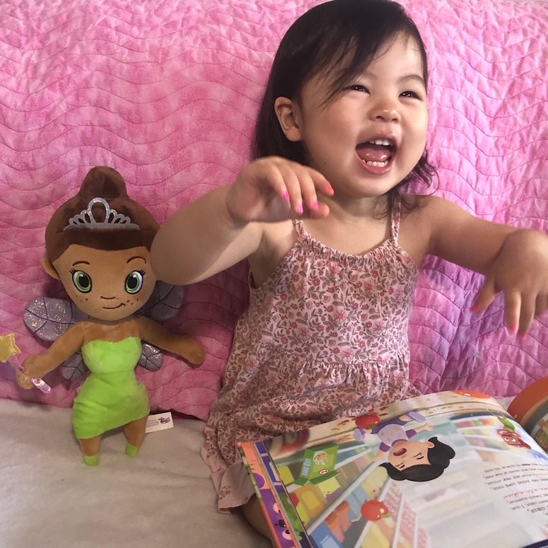 A child with a personalized milestone book from Hooray Heroes.