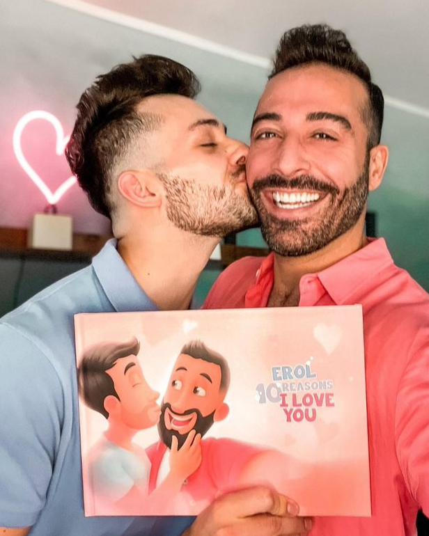 A happy couple with a personalized book for same-sex couples.