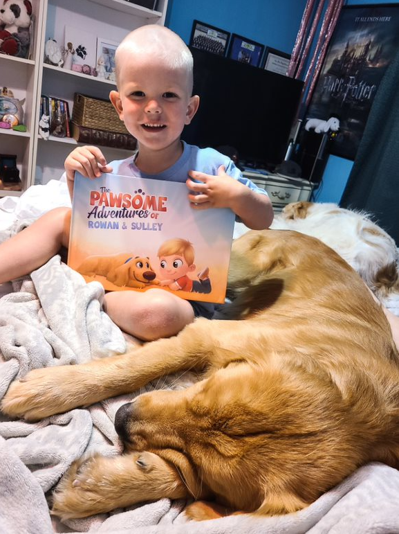 A boy and his dog with a personalized book for kids and pets.