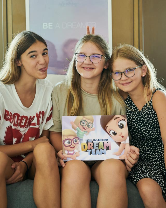 Three sisters with the new personalized books for siblings from Hooray Heroes called The Dream Team.