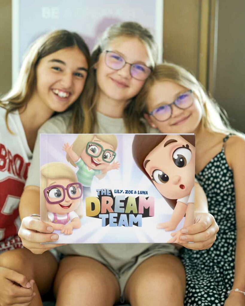 The sisters with a personalized book for 3 siblings from Hooray Heroes called The Dream Team.