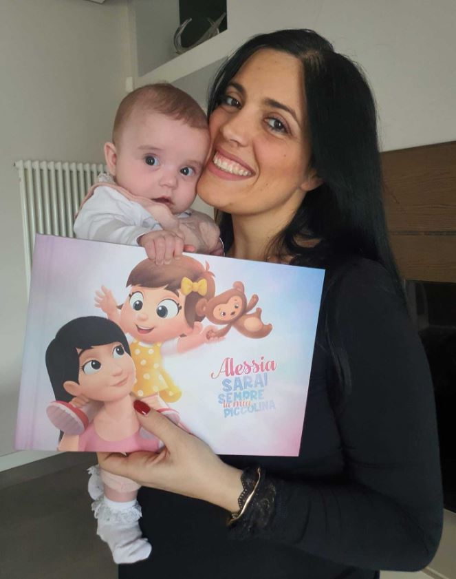 A little girl called Alessia and her mother holding a personalized book for kids from Hooray Heroes.