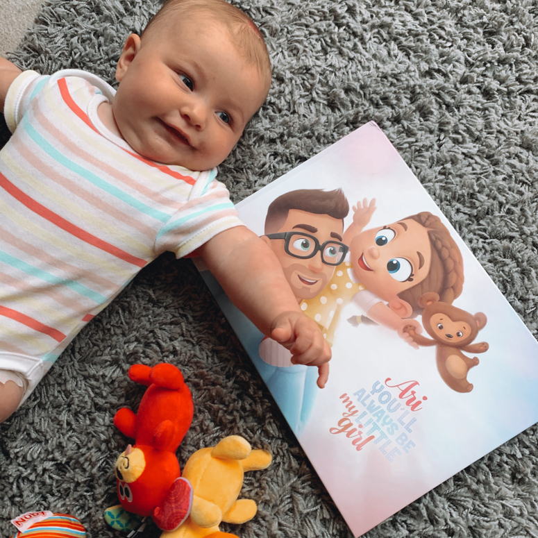 A baby girl named Ari with a personalised book by Hooray Heroes.