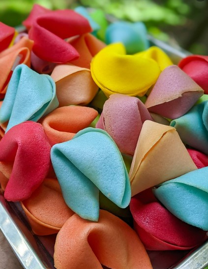 A pile of fortune cookies of various colors.