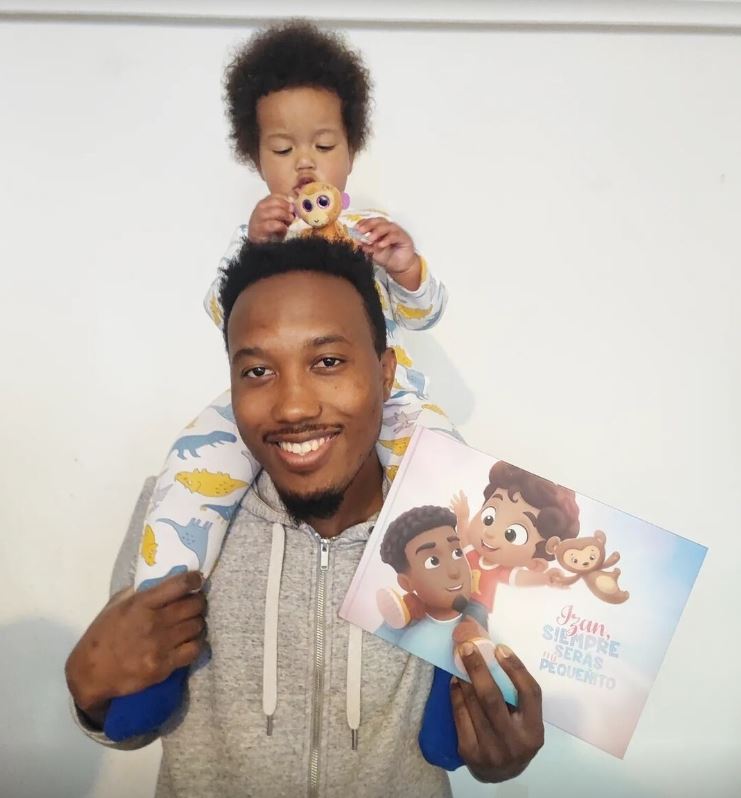 A baby boy named Izan and his dad with a personalized book from Hooray Heroes.