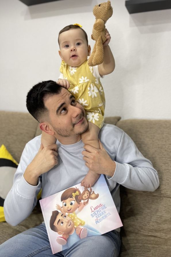A baby girl named Luna with her father holding a personalised book by Hooray Heroes.