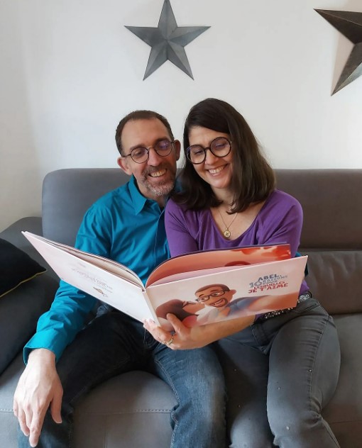 A couple enjoying the French version of a Hooray Heroes personalized love book.
