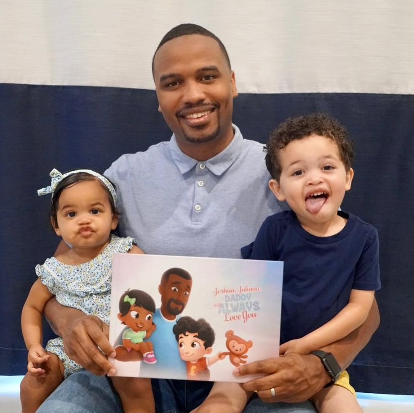 A father and two kids with a personalized book from Hooray Heroes.