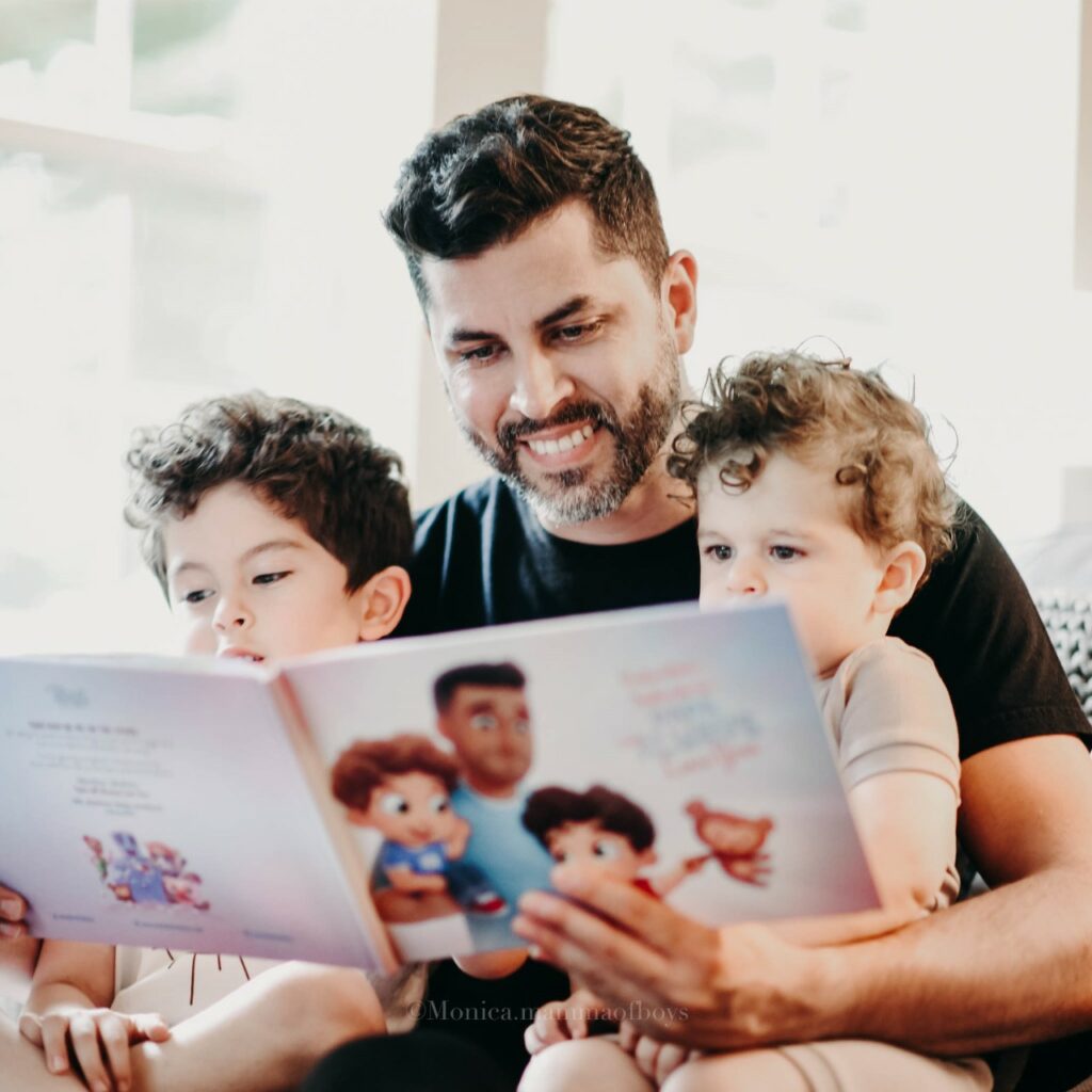 A dad reading a personalized book to her two kids.