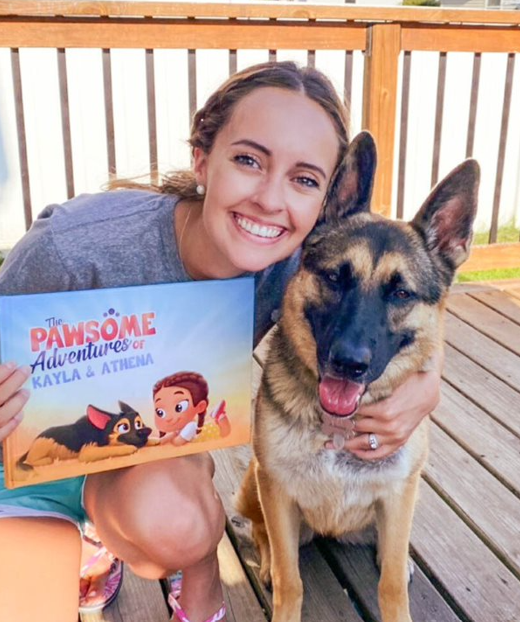 A woman and her dog with a personalized book for pets and owners from Hooray Heroes.