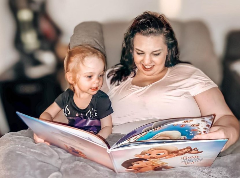 A mother and child reading a custom Hooray Heroes book for the two of them. 
