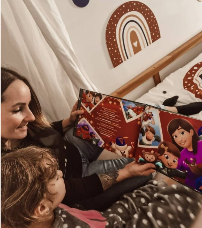 A mother and child read a Hooray Heroes custom Christmas book.