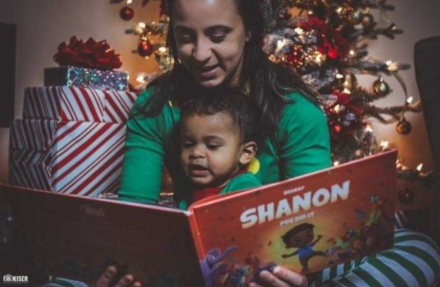A mother reads her child a personalized milestone books about their exciting firsts, the best gift for Christmas.