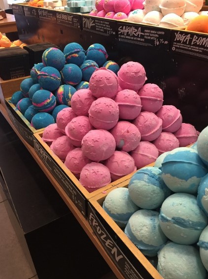 A number of different bath bombs on display in a store. 
