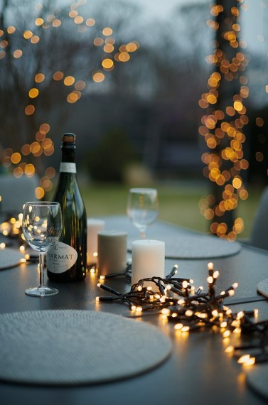 An outdoor Christmas dinner set up complete with fairy lights. 